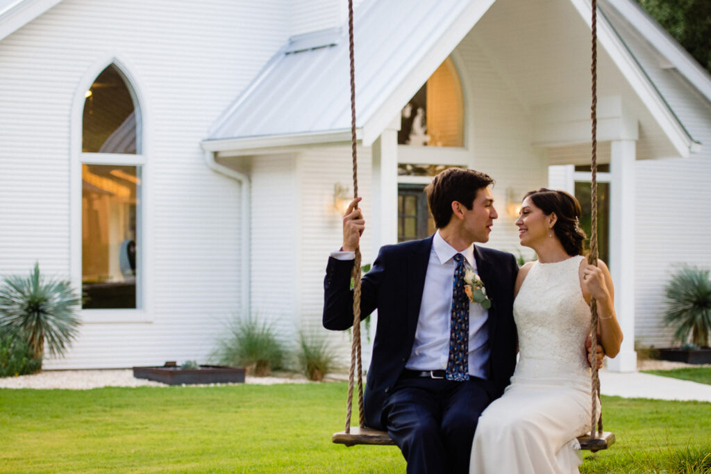 bride and groom on swing at the Chandelier of Gruene