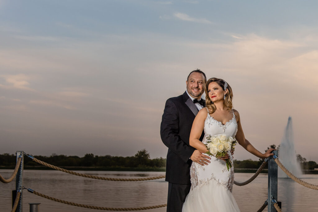 bride and groom posing lakeside at the Red Berry Estate