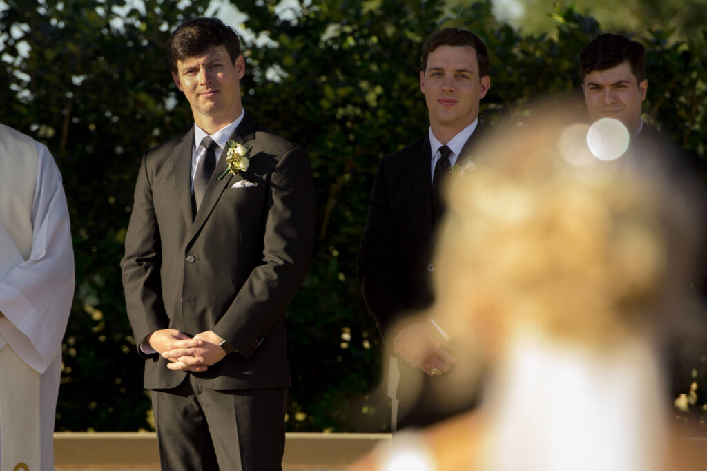 groom watching his bride-to-be approach the altar