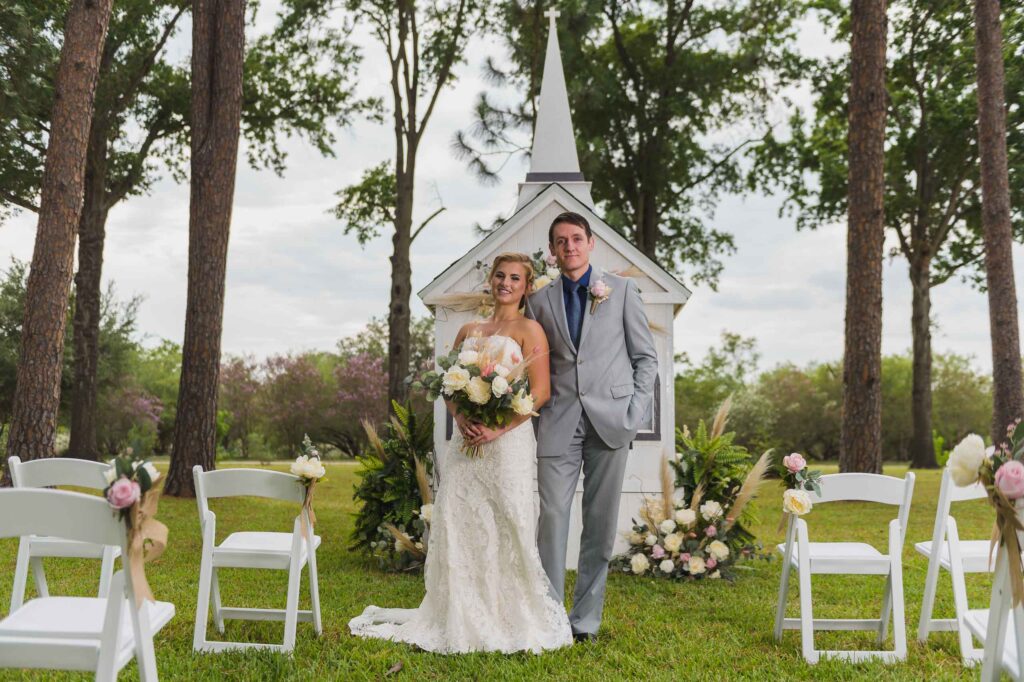 posed bride and groom in front of the texas traveling wedding chapel