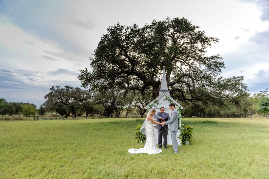 the texas traveling wedding chapel in a open field, ceremony being performed