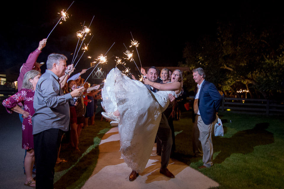 groom sweeps bride off her feet during the sparkler exit at the firefly farm