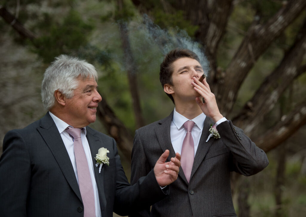 groom and his dad smoking a celebratory stogy just prior to the wedding ceremony