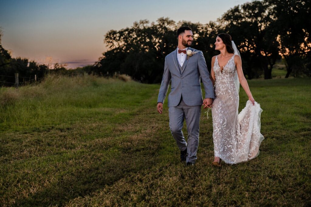 bride and groom walking at sunset during the golden hour