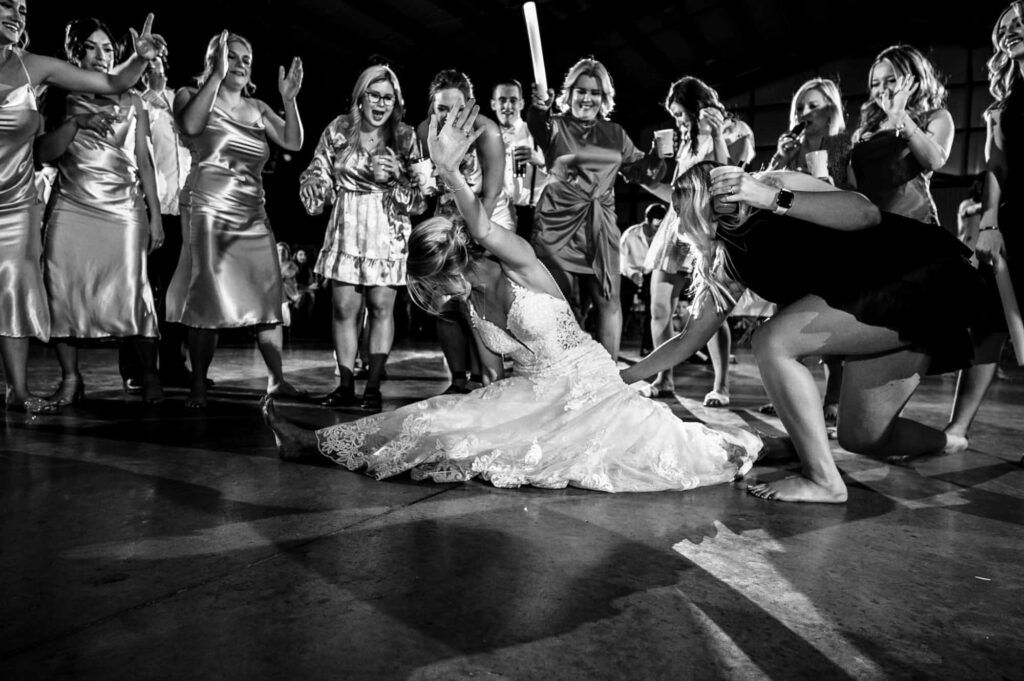 bride doing the splits in her wedding gown on the dance floor on her dallas wedding day